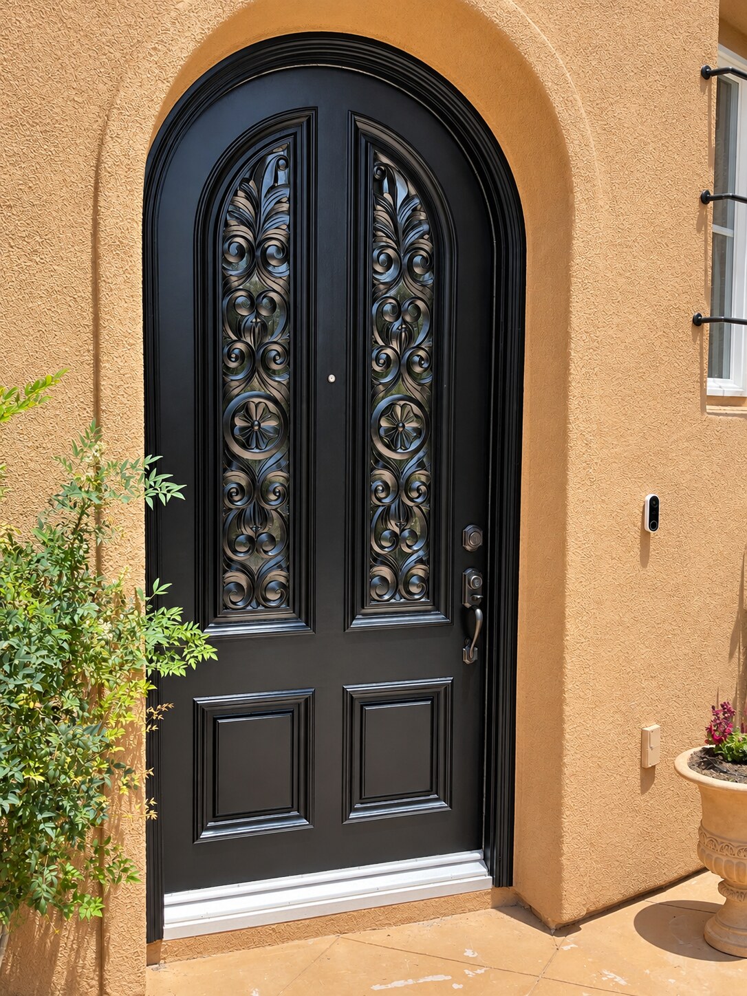All-black arched entry door with a smooth painted finish