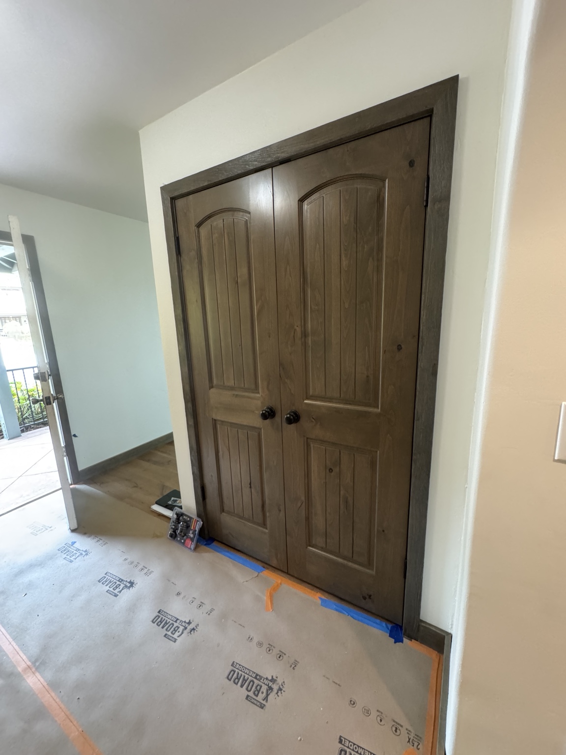Stained double interior wood doors with arched panels and matching trim